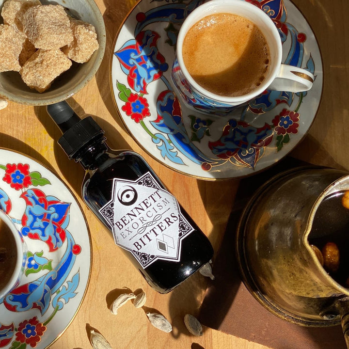 Aromatic Exorcism Bitters bottle by Bennett Bitters with Turkish coffee, cups, and sugar.